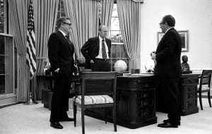 President Ford at oval office desk with Kissinger and Rockefeller